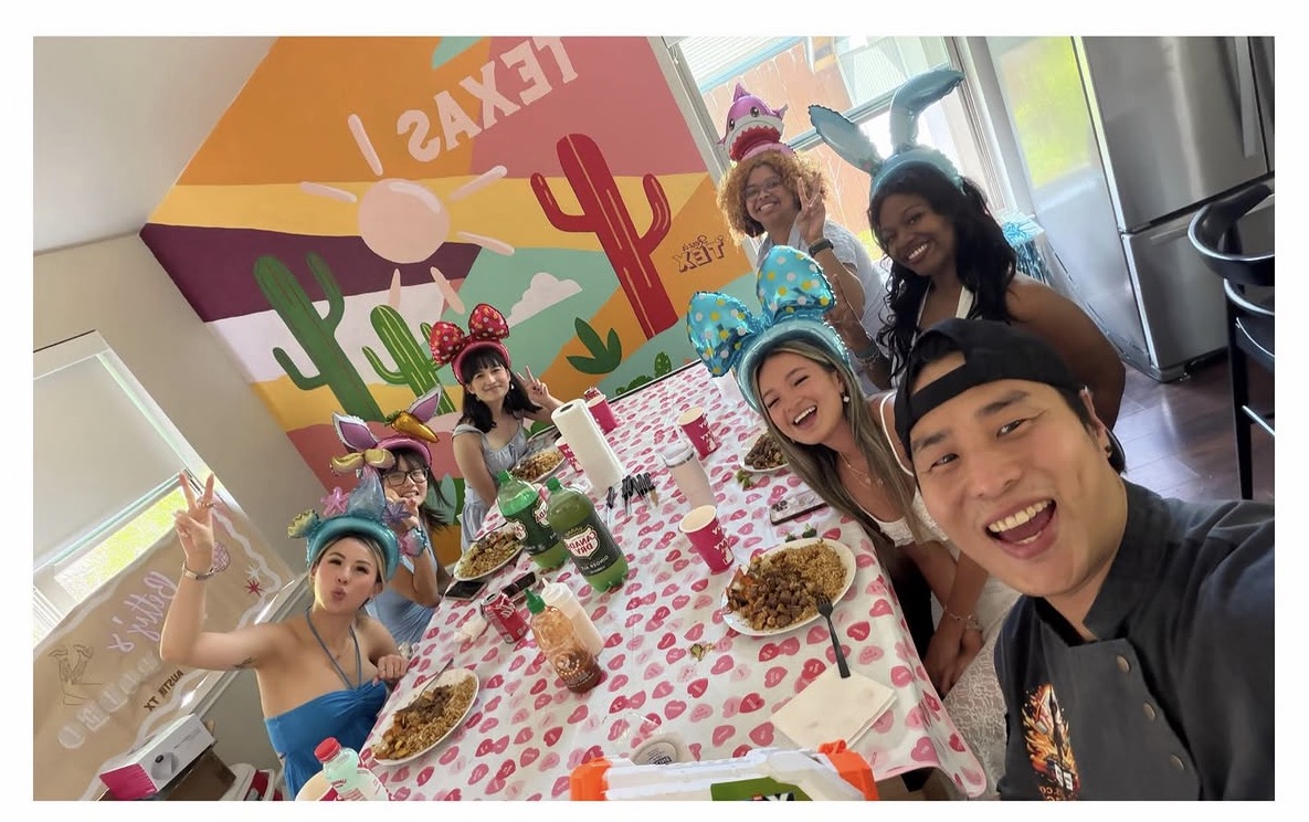 Guests and their hibachi chef gathered around a festive dining table